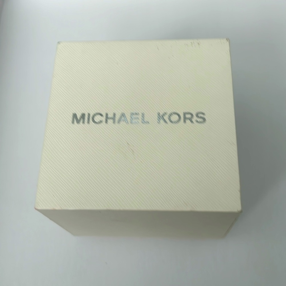 This is a Michael Kors watch. It has a Tan leather band that doubles around!
